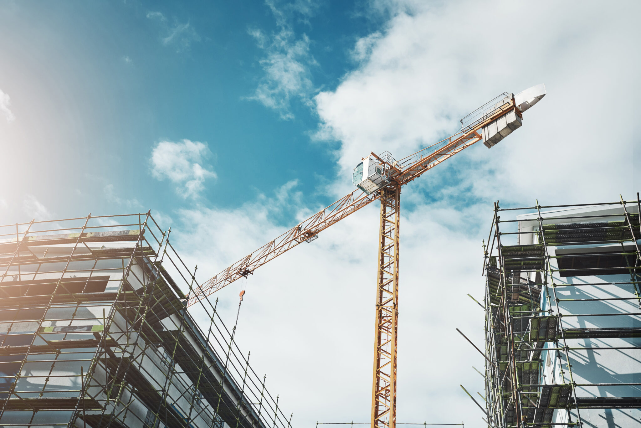 Is it a bird Is it a plane No, its a crane. Shot of a crane and building at a construction site